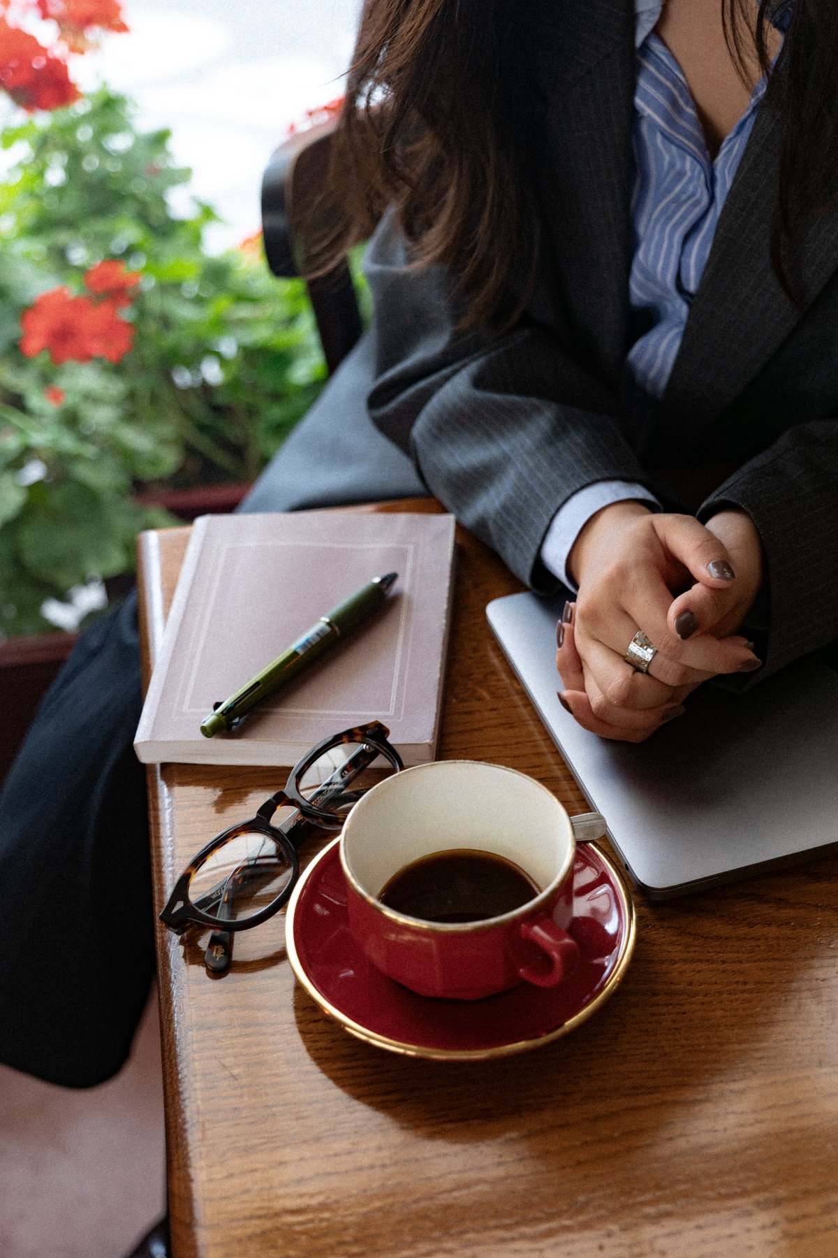 Notebook, pen, glasses and a coffee cup on a café table
